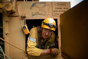 worker in confined space entrance with gas detector